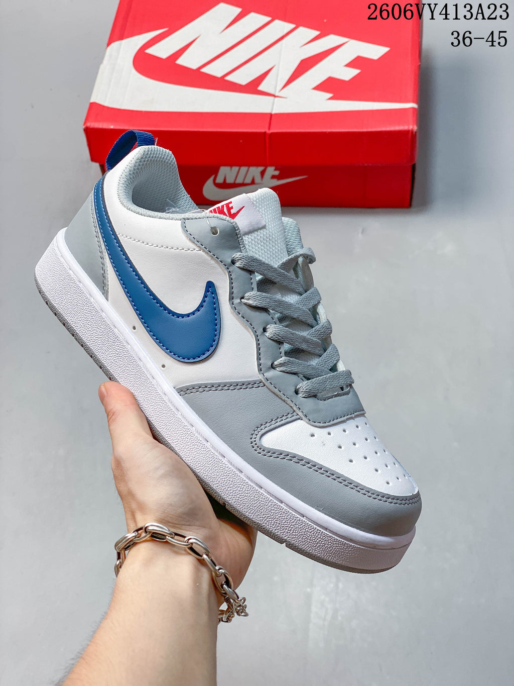 White sneaker with a blue Swoosh and gray overlays