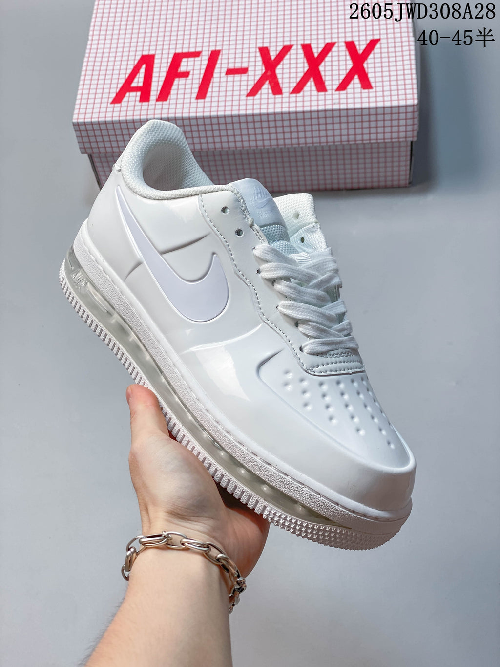 Angled side view of a white lace-up sneaker with a white Swoosh