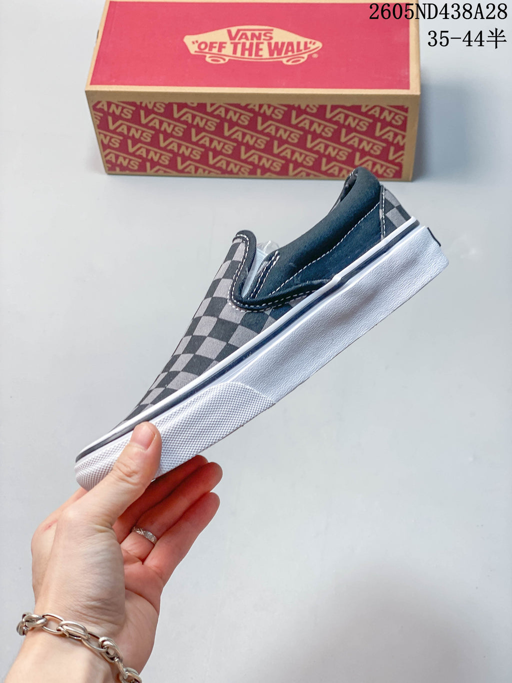 Side profile of a checkerboard slip-on sneaker with a white sole
