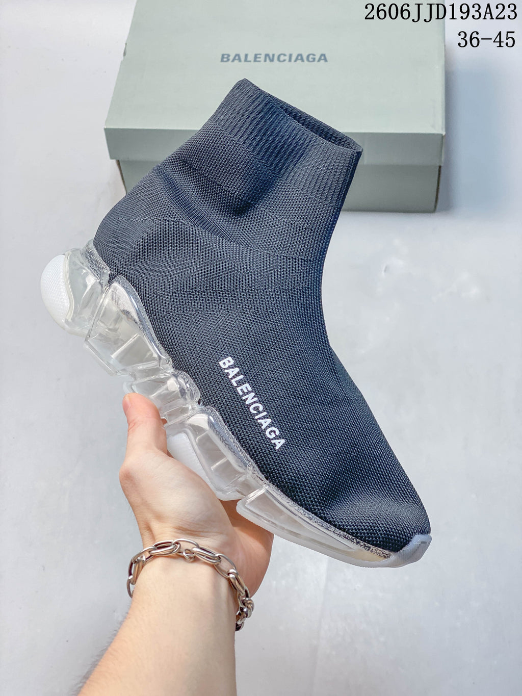 A gray-blue Balenciaga sock-style sneaker with a translucent segmented sole and white accents.