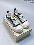 Pair of navy and cream Fendi low-top sneakers with patterned side panels on a shoe box.