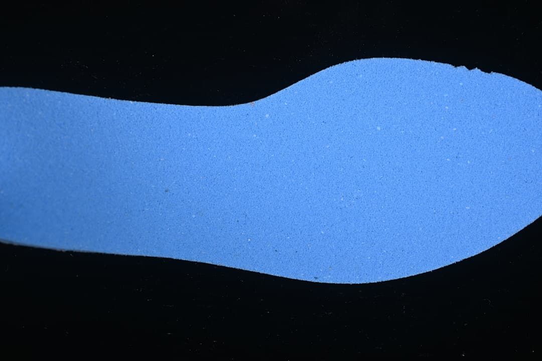 Close-up of a blue shoe insert shown against a dark background.