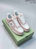 Pink and white low-top sneakers with Labubu-themed details displayed on a green box