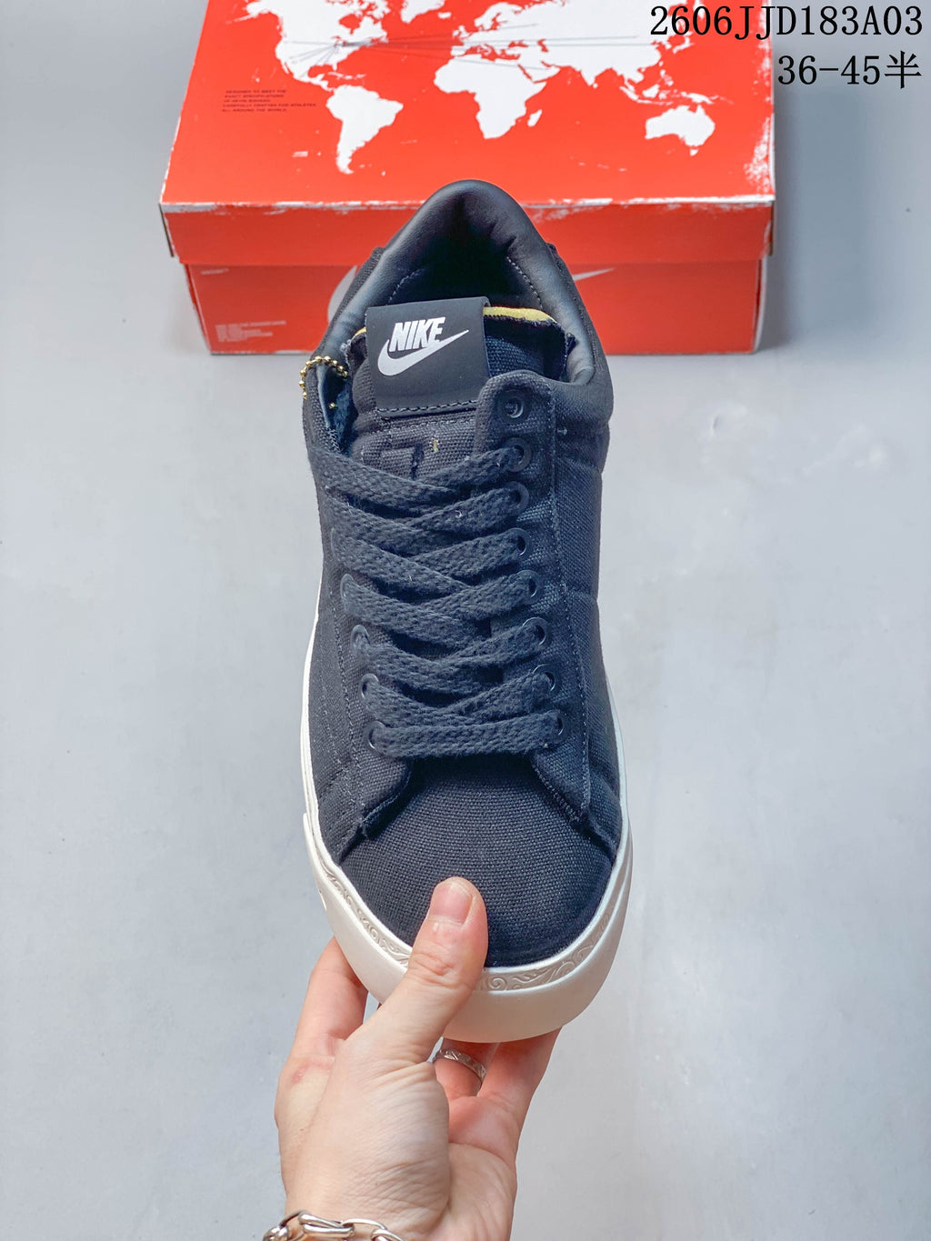 Front view showing the navy laces, tongue tab, and white sole