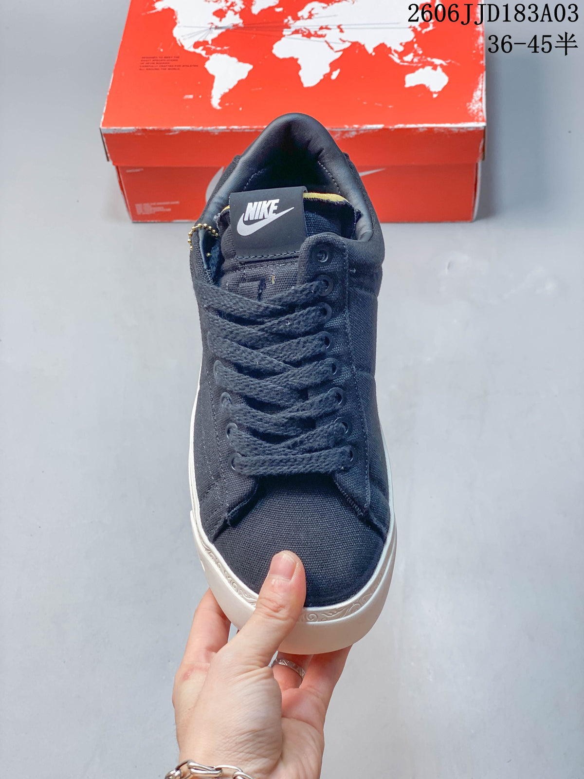 Front view showing the navy laces, tongue tab, and white sole