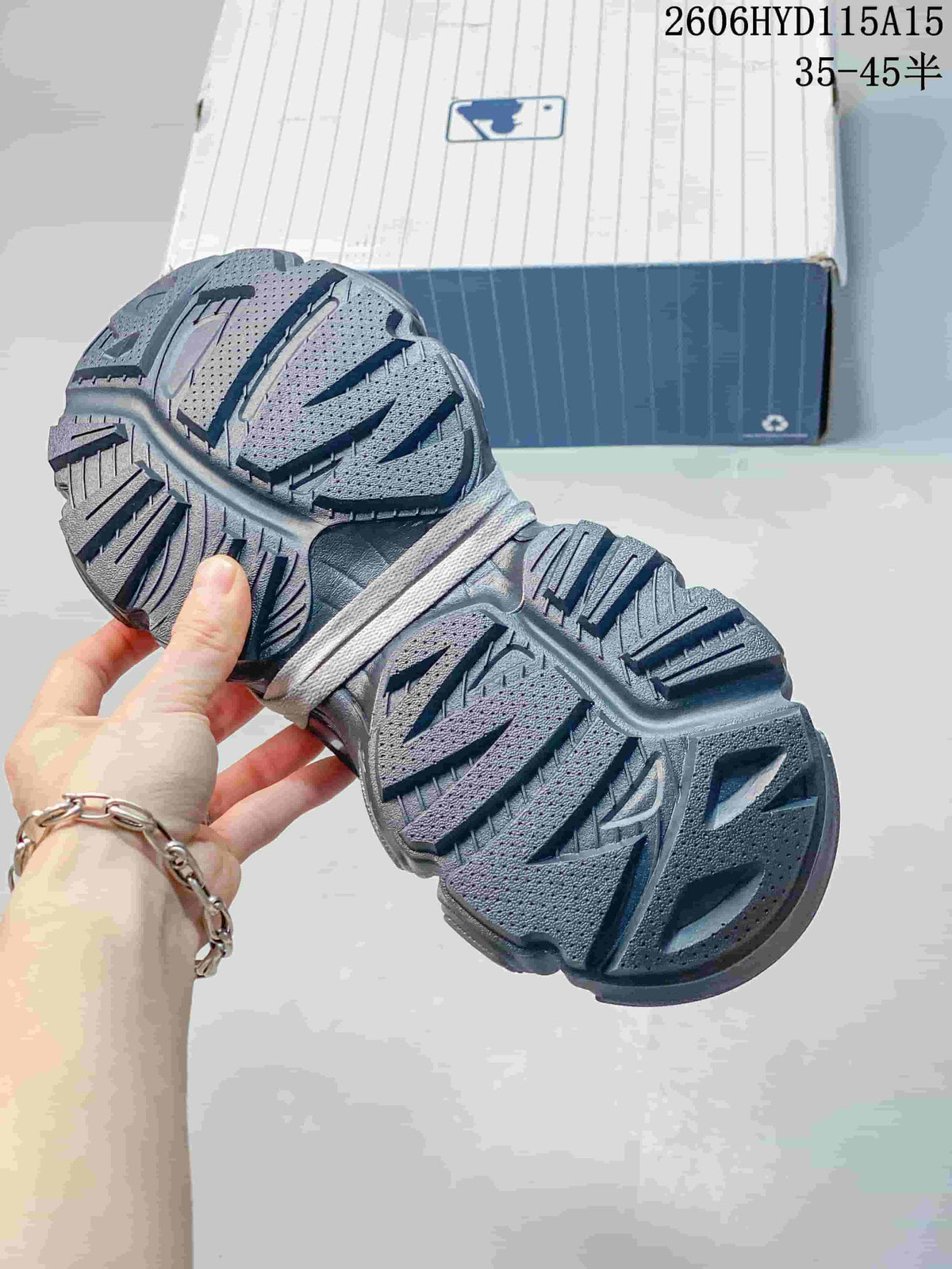 Close-up of the patterned outsole on the silver-gray MLB sneakers