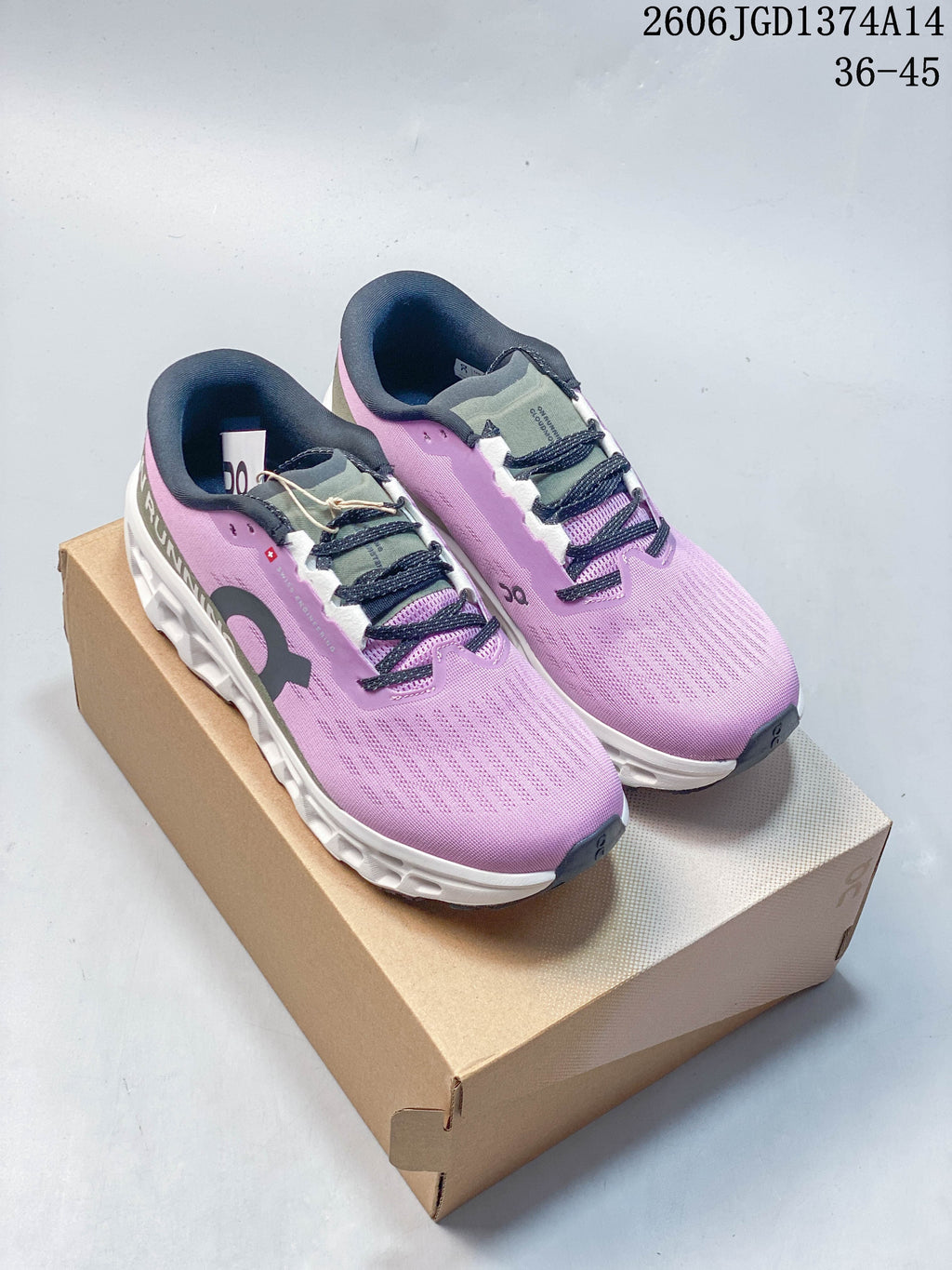Pair of lilac and olive On Cloudmonster 3 running shoes shown from above and placed on a shoe box.