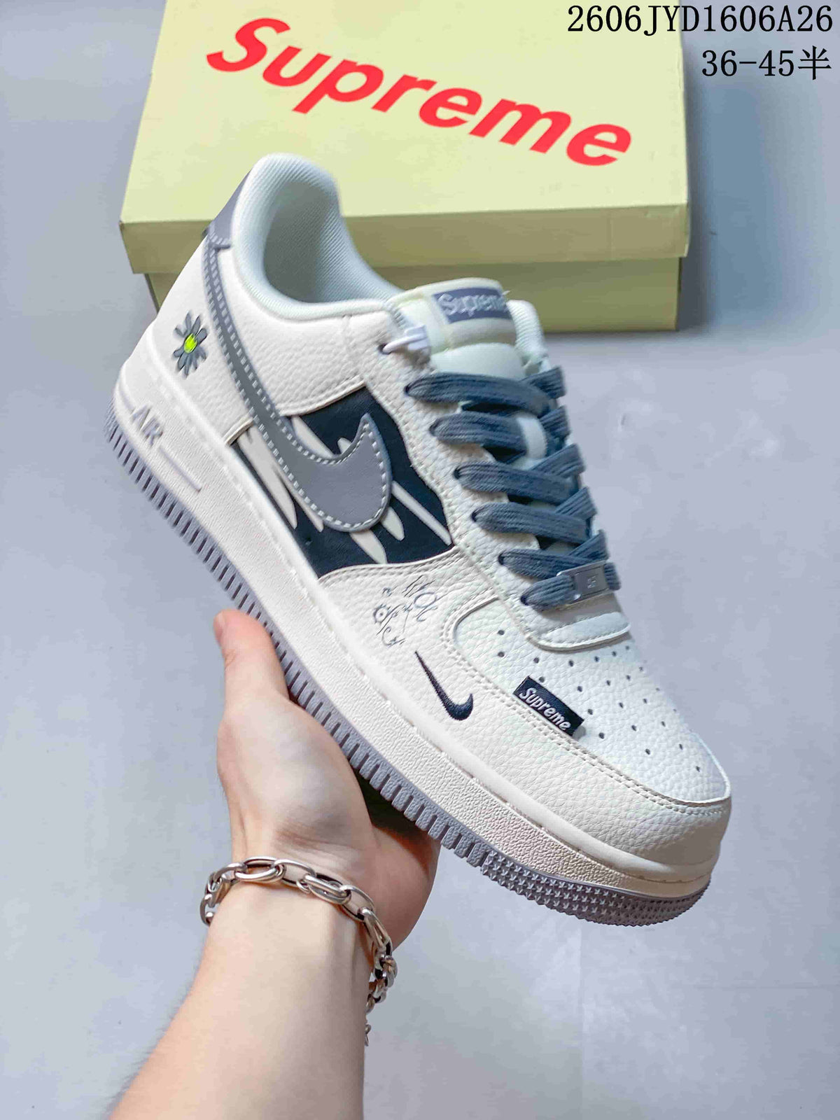 White low-top sneaker with gray and black graphics and gray laces