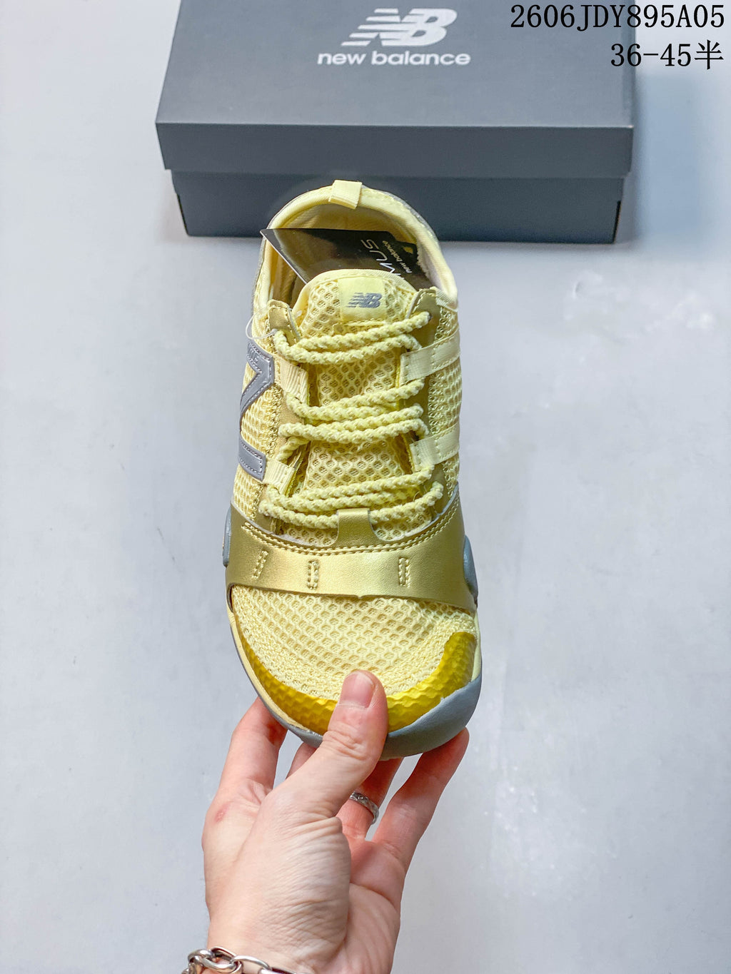 Front view of the sneaker showing the laces, mesh-like upper, and yellow toe accents