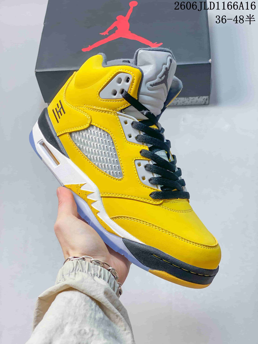 Angled side view of a yellow Air Jordan 5 Retro sneaker