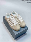 Pair of beige-toned AMIRI Pacific Bones low-top sneakers with white bone-shaped side details and translucent gum-colored soles.