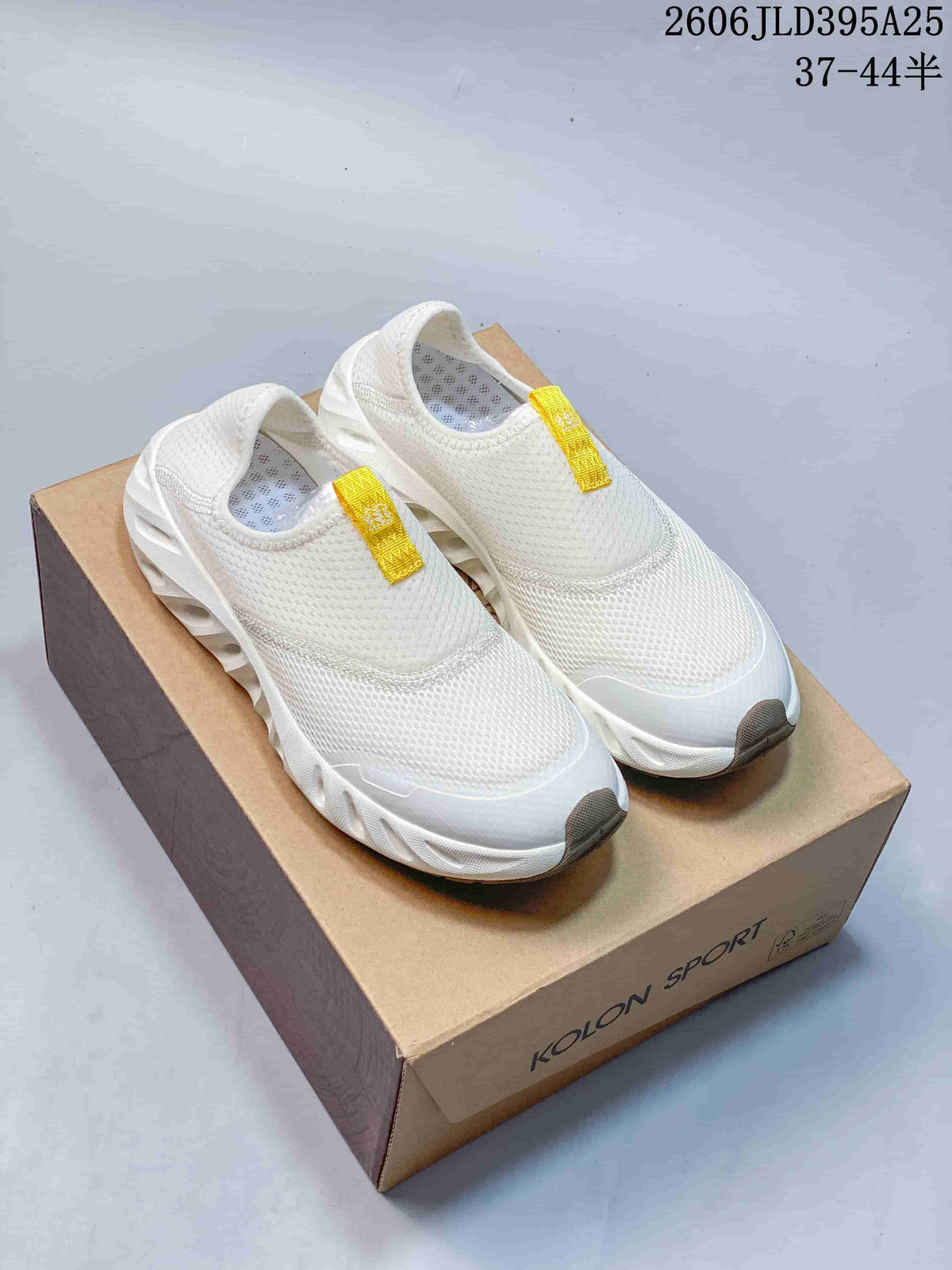 White KOLON SPORT Galah slip-on shoes with yellow pull tabs shown on a shoe box; image overlay lists code 2606JLD395A25 and sizes 37–44.5.