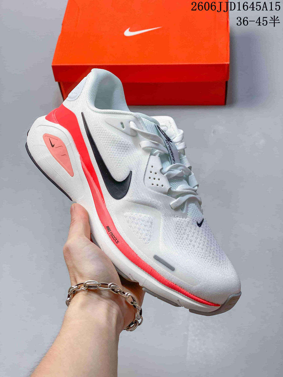 White Nike Air Structure 26 running shoe with coral accents and a dark Swoosh.