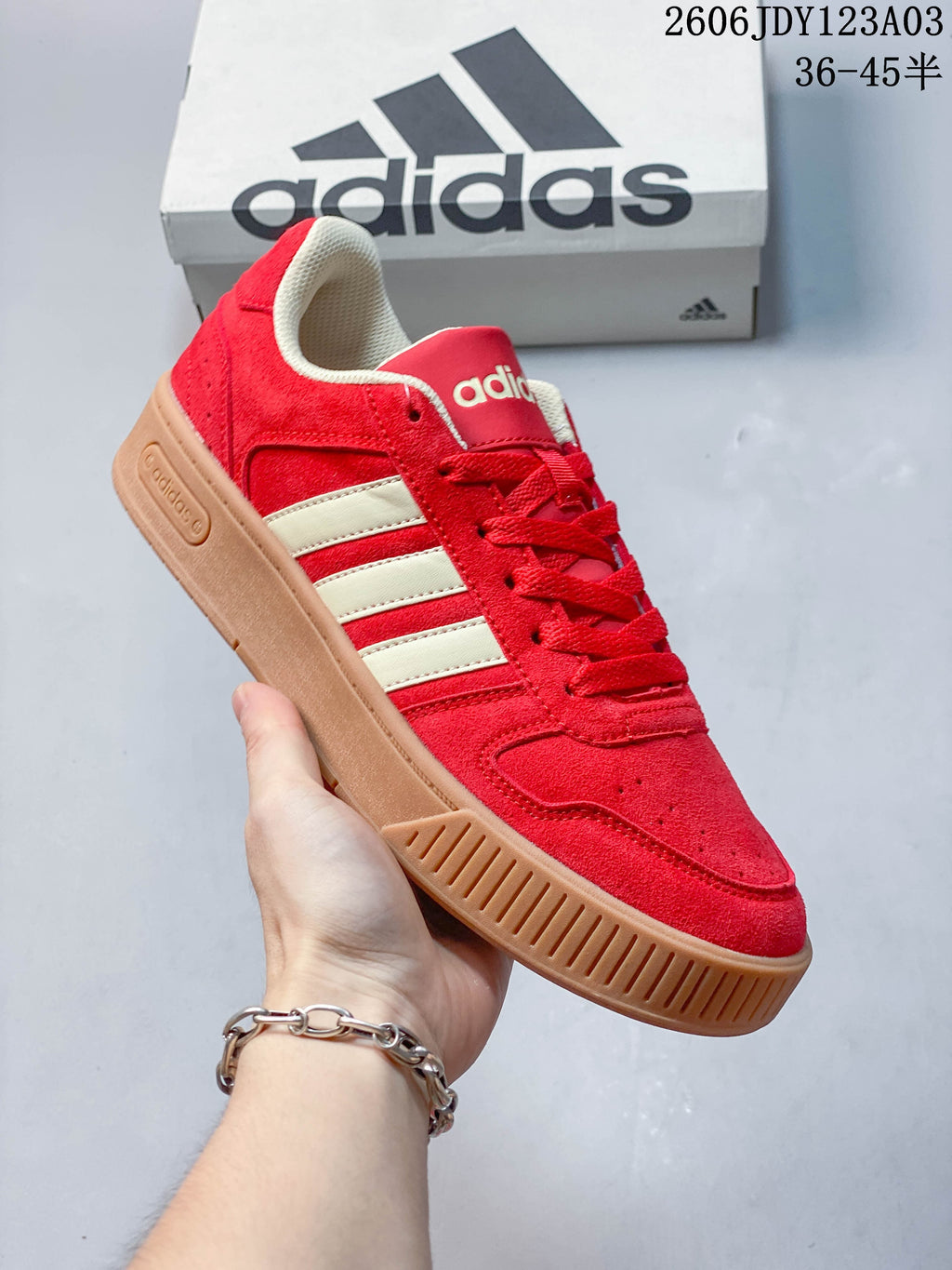 Red Adidas low-top sneaker shown from the side with a gum-colored ridged sole.