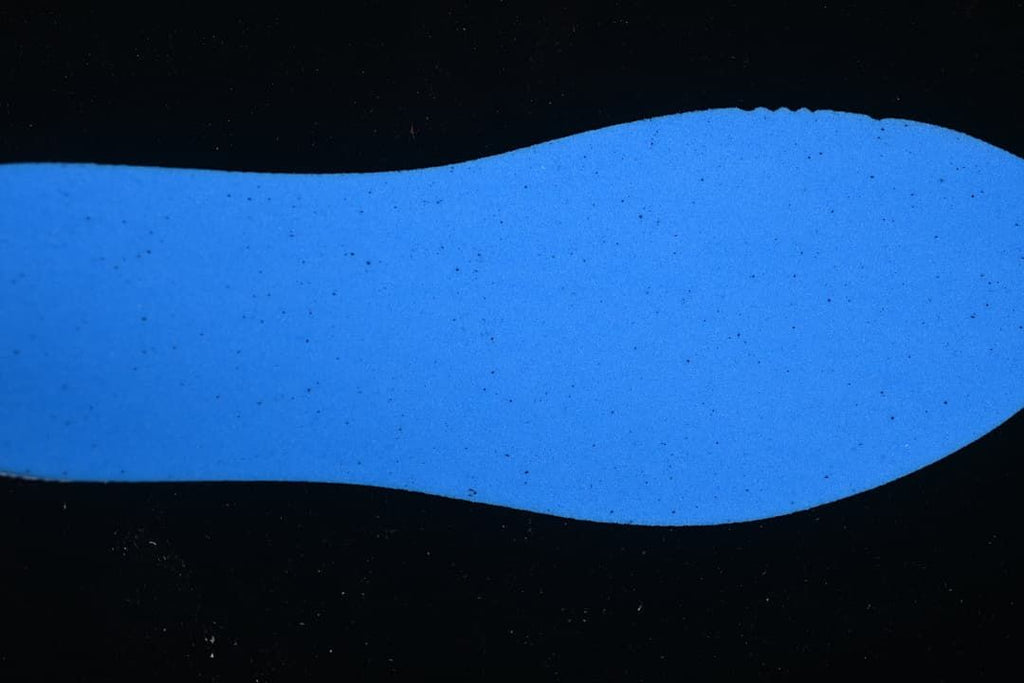 Blue-lit close-up view of a shoe-shaped surface