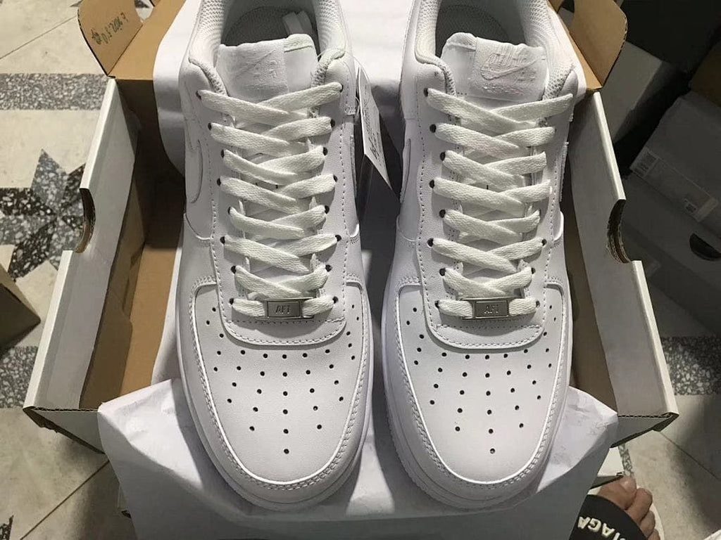 Pair of white low-top sneakers shown from above in an open shoe box.