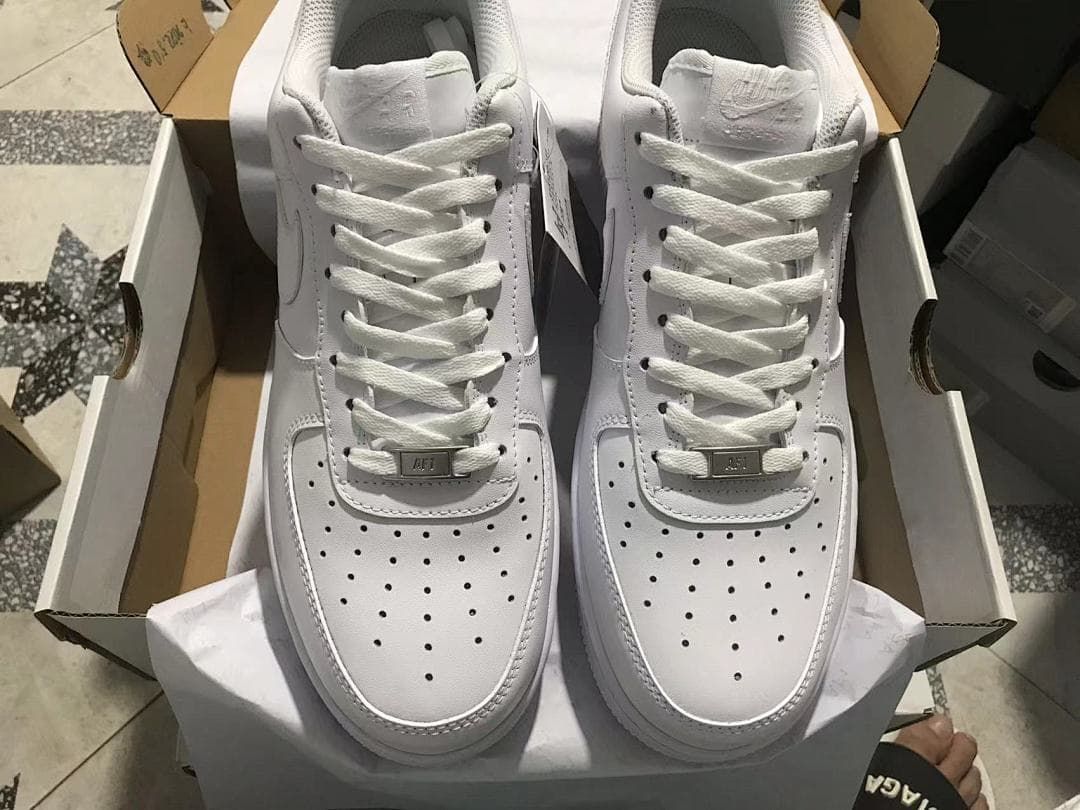 Pair of white low-top sneakers shown from above in an open shoe box.