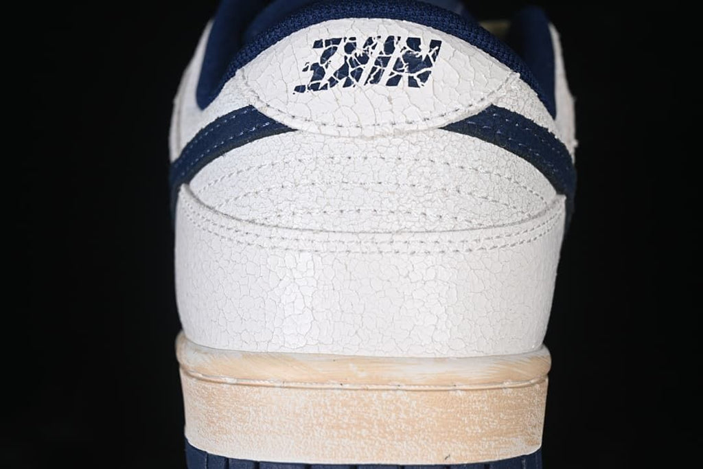 Rear view showing textured off-white heel, navy accents, and warm-toned midsole