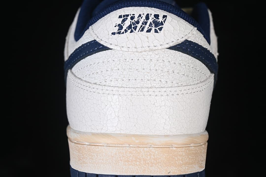 Rear view showing textured off-white heel, navy accents, and warm-toned midsole