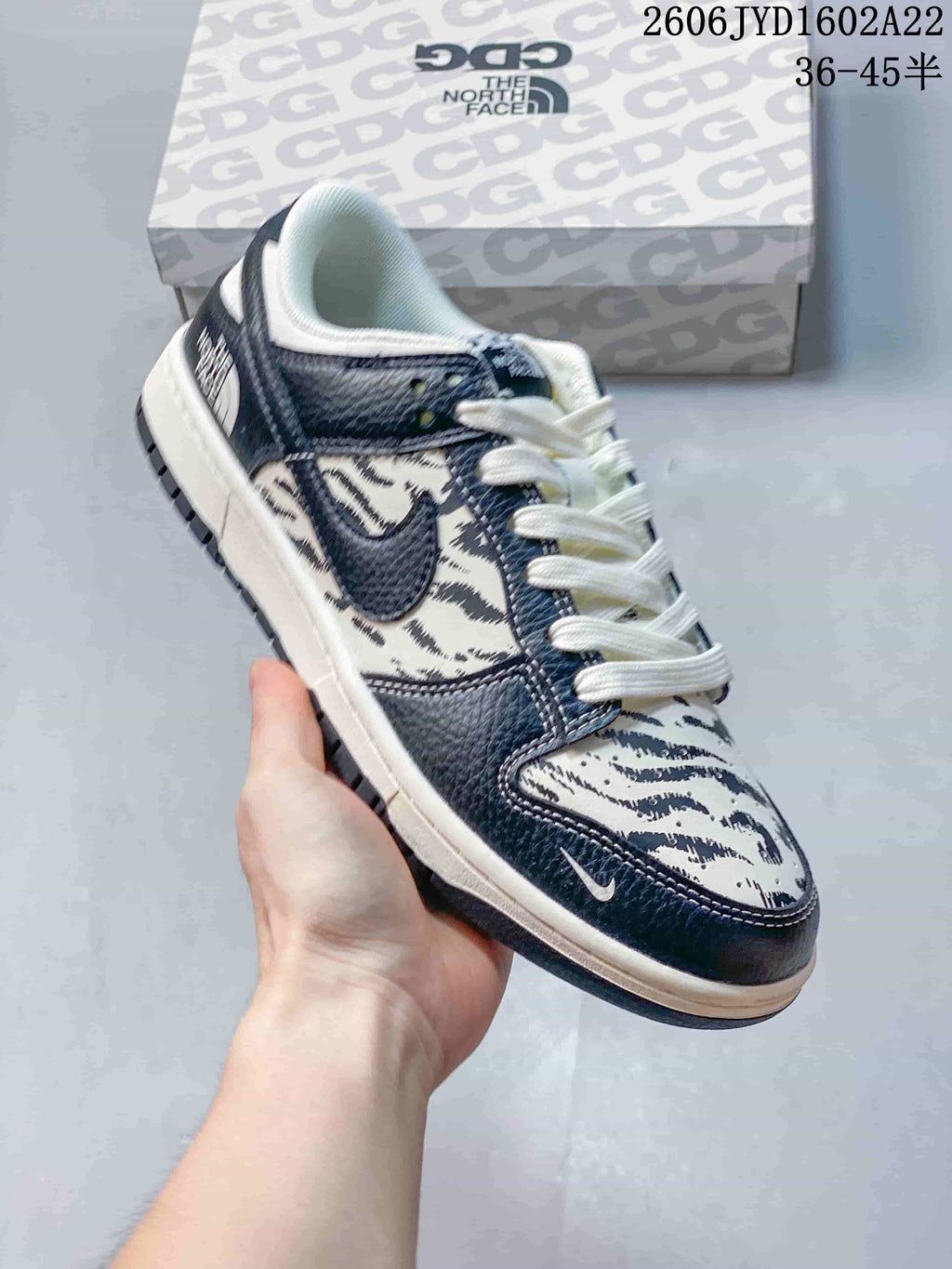Dark blue and cream low-top sneaker with an animal-inspired pattern and white laces