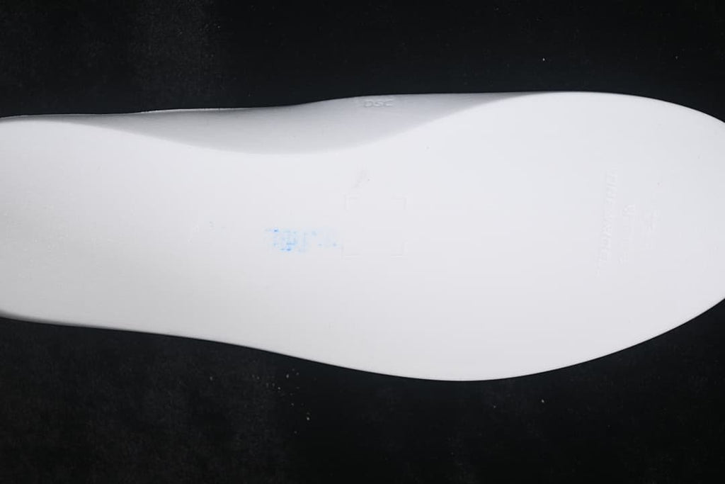 Light-colored sneaker outsole shown from below.