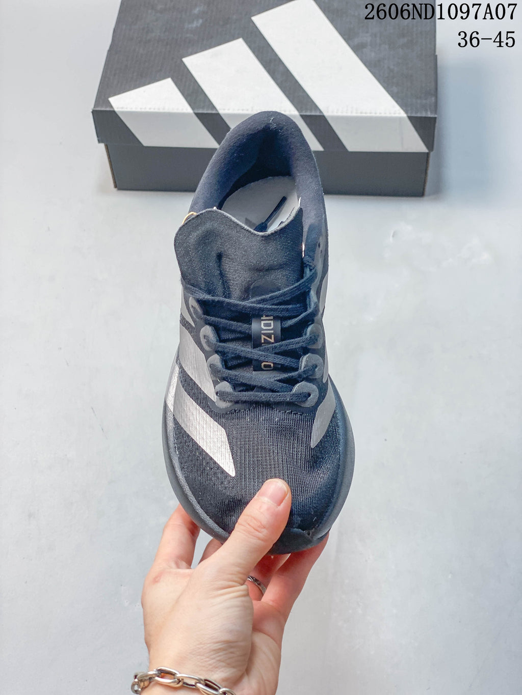 Top view of a dark gray lace-up running shoe with silver-tone side stripes.