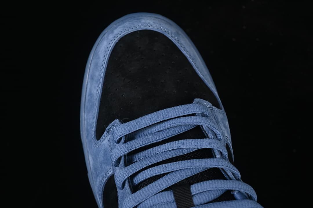 Top-down close-up of the perforated black toe box and blue laces