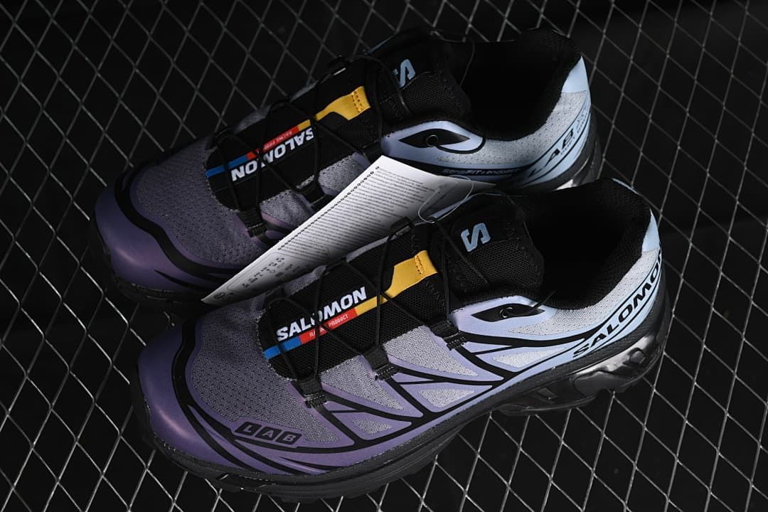 Pair of gray, blue-violet, and black Salomon shoes with cord lacing.