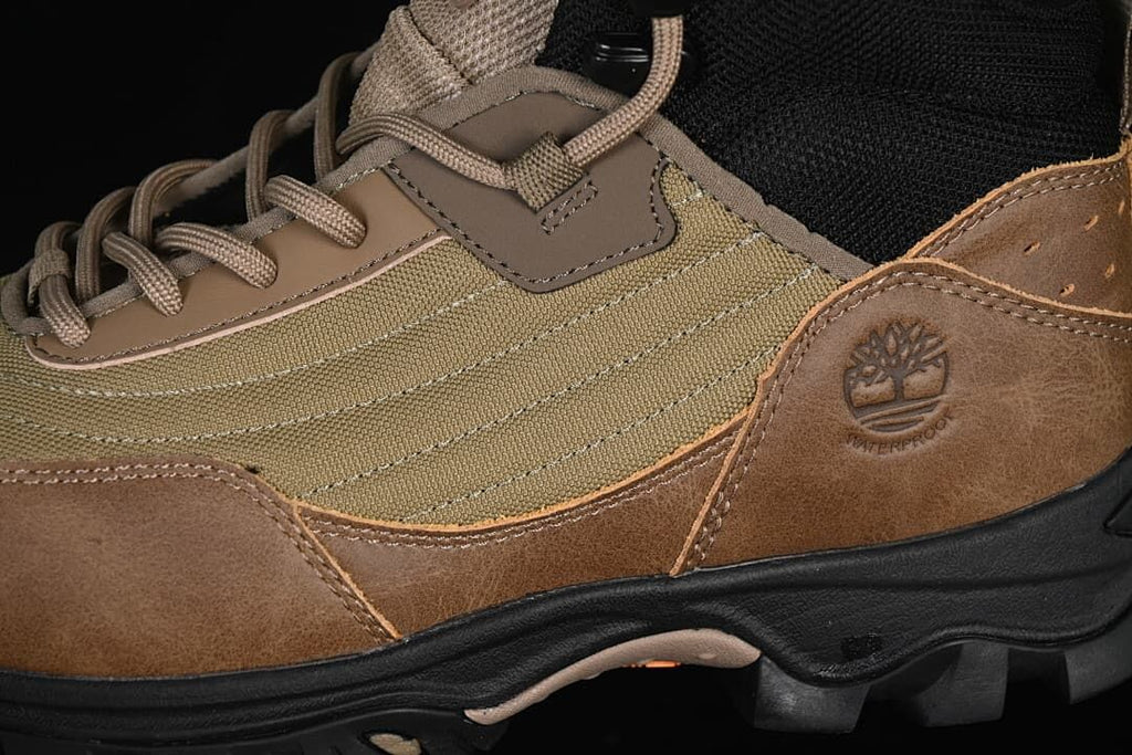 Close-up of olive side panels, brown overlays, and the embossed Timberland tree logo.