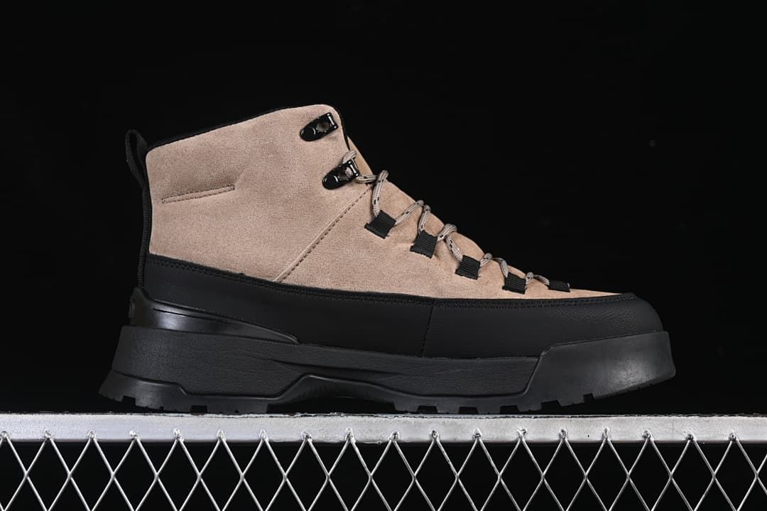 Side profile of a brownish-black mid-cut boot with a black toe guard and outsole
