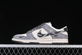 Side view of gray and cream low-top sneakers with a printed black Swoosh and patterned laces