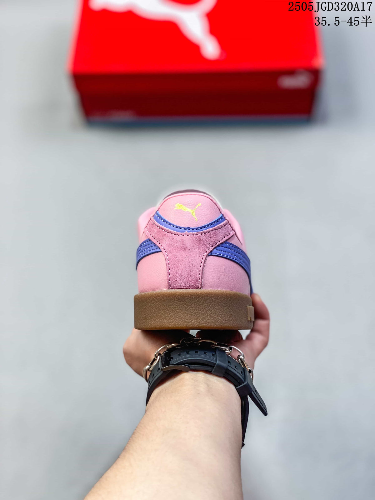 Rear view of a pink PUMA sneaker with blue heel stripes and a gum-colored sole