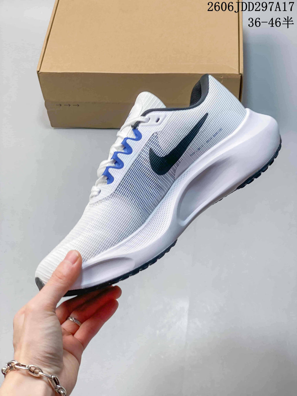Side profile of a white Nike Zoom Fly 5 running shoe with dark swoosh and blue lace accents.