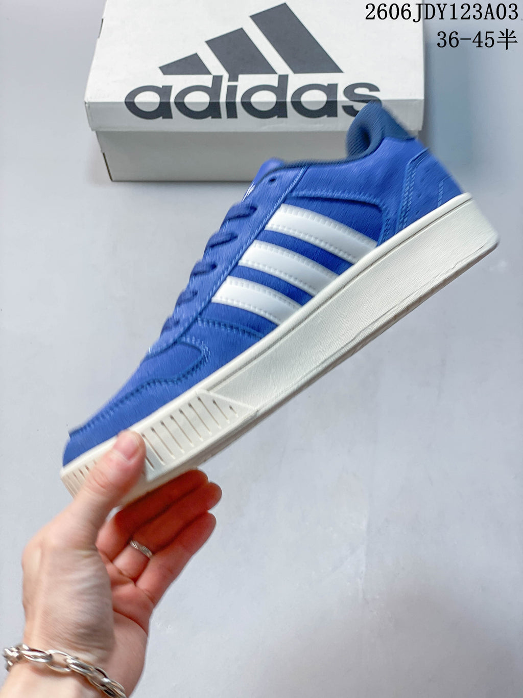 Side profile showing the blue upper, white stripes and off-white sole