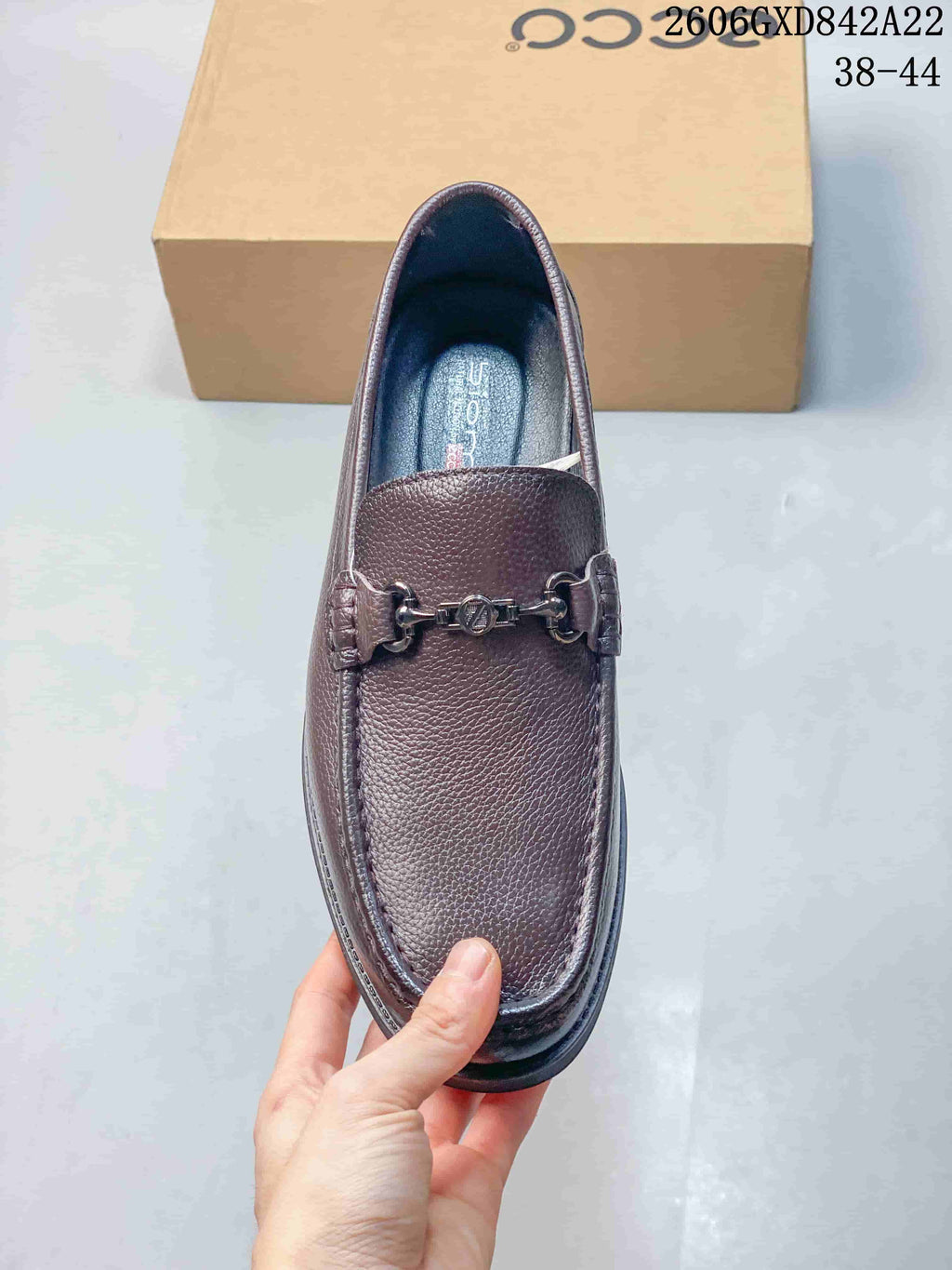 Top view of a brown loafer with moc-toe stitching and metal bit detail
