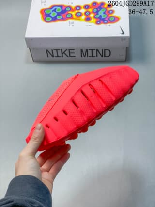 Side view of the red Nike Mind slide showing the textured upper, open heel and sculpted sole.