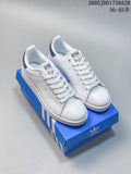 Pair of white low-top sneakers with dark blue heel tabs, photographed on a blue shoe box; image overlay shows a size range.