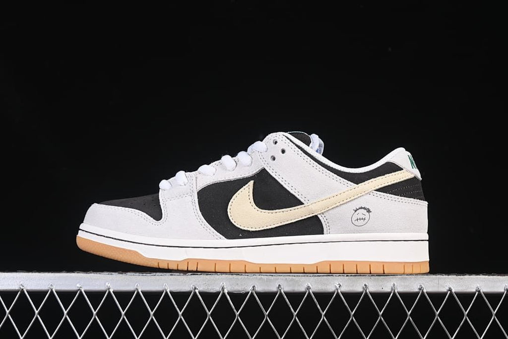 Side view of a Nike SB Dunk Low Pro sneaker in black, light neutral, and cream.