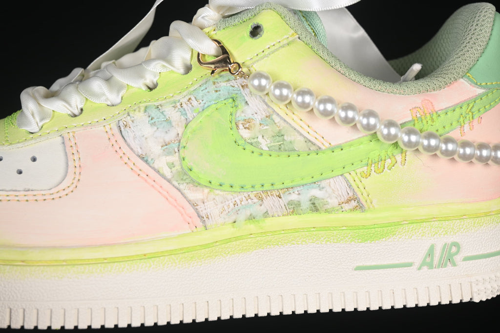 Close-up of pastel green and pink Nike Air Force 1 '07 side panel with pearl-like trim