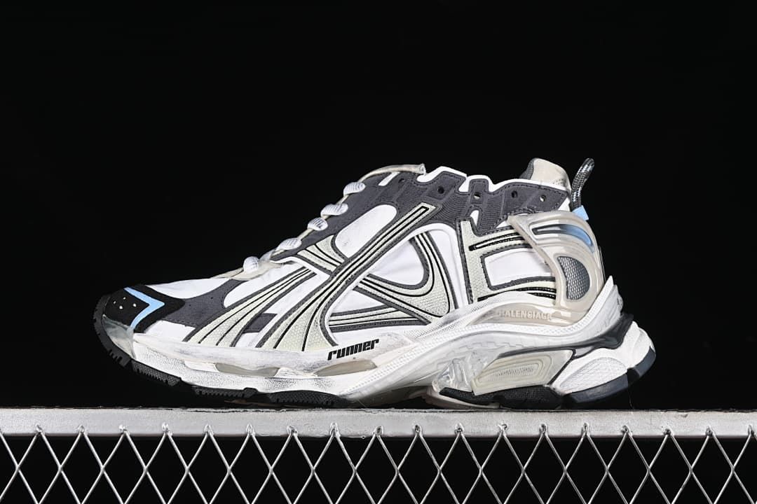 Side view of a beige, white and charcoal Balenciaga Runner sneaker with light blue accents.
