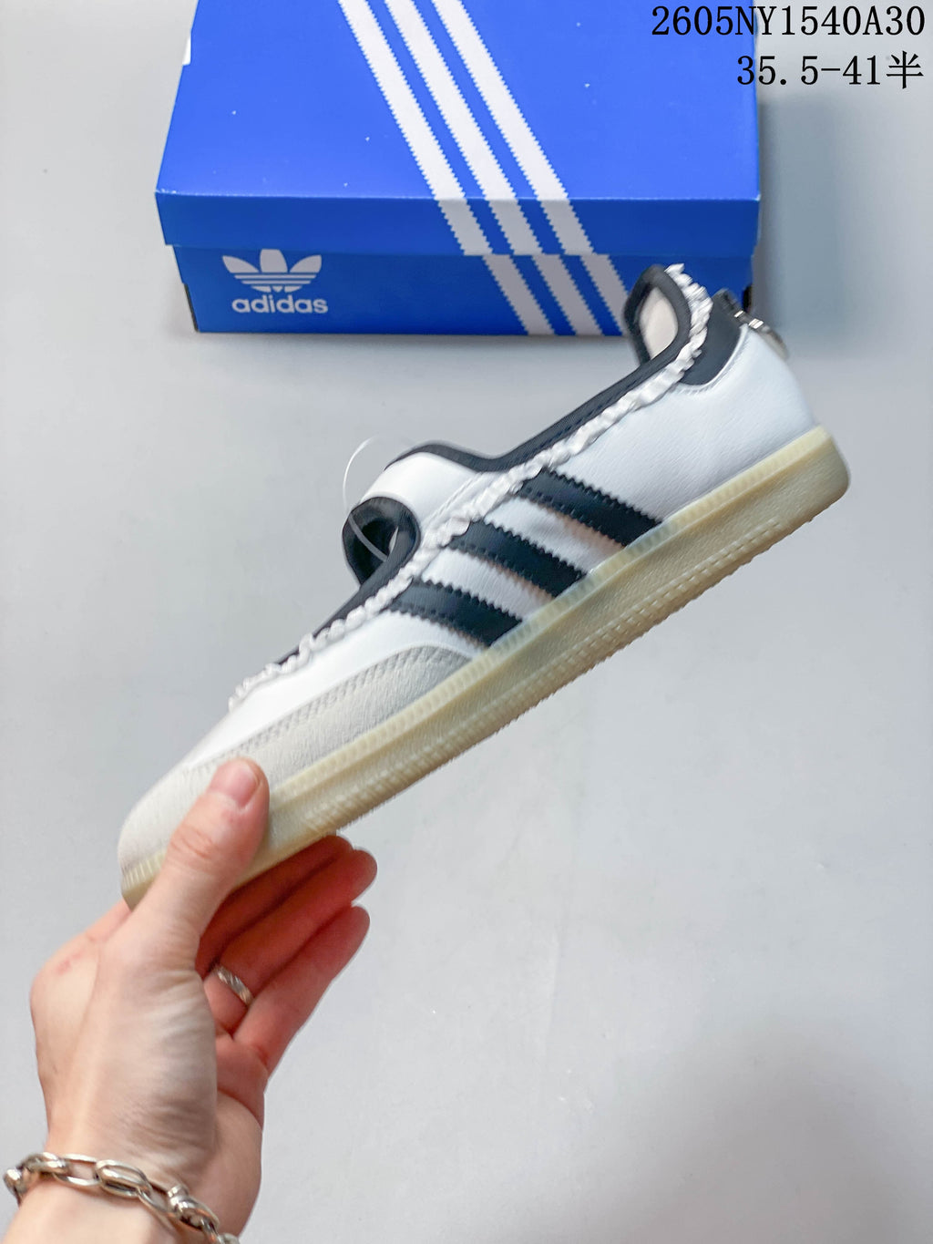 Side view of a white Samba Jane sneaker with black stripes and gum-tone sole
