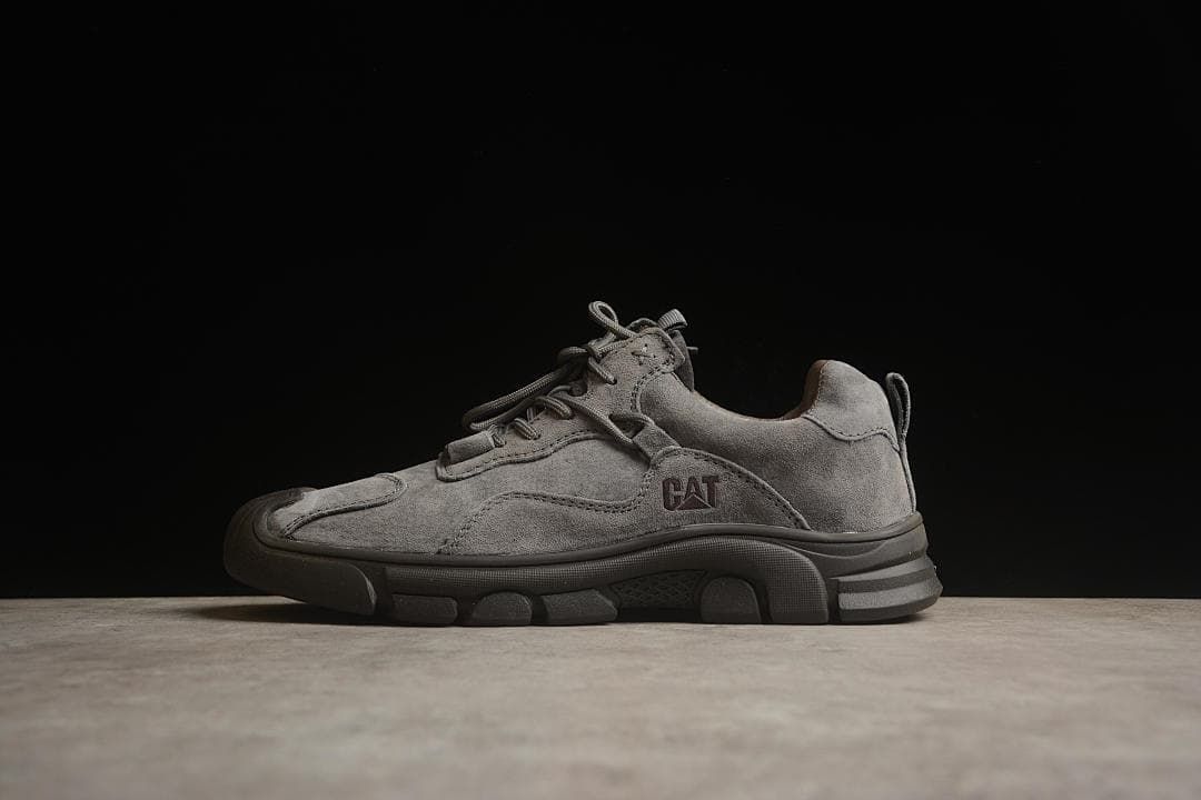 Side view of the gray sneaker against a dark background.