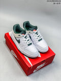 Pair of white Nike Full Force Low sneakers with dark green accents on a red shoe box