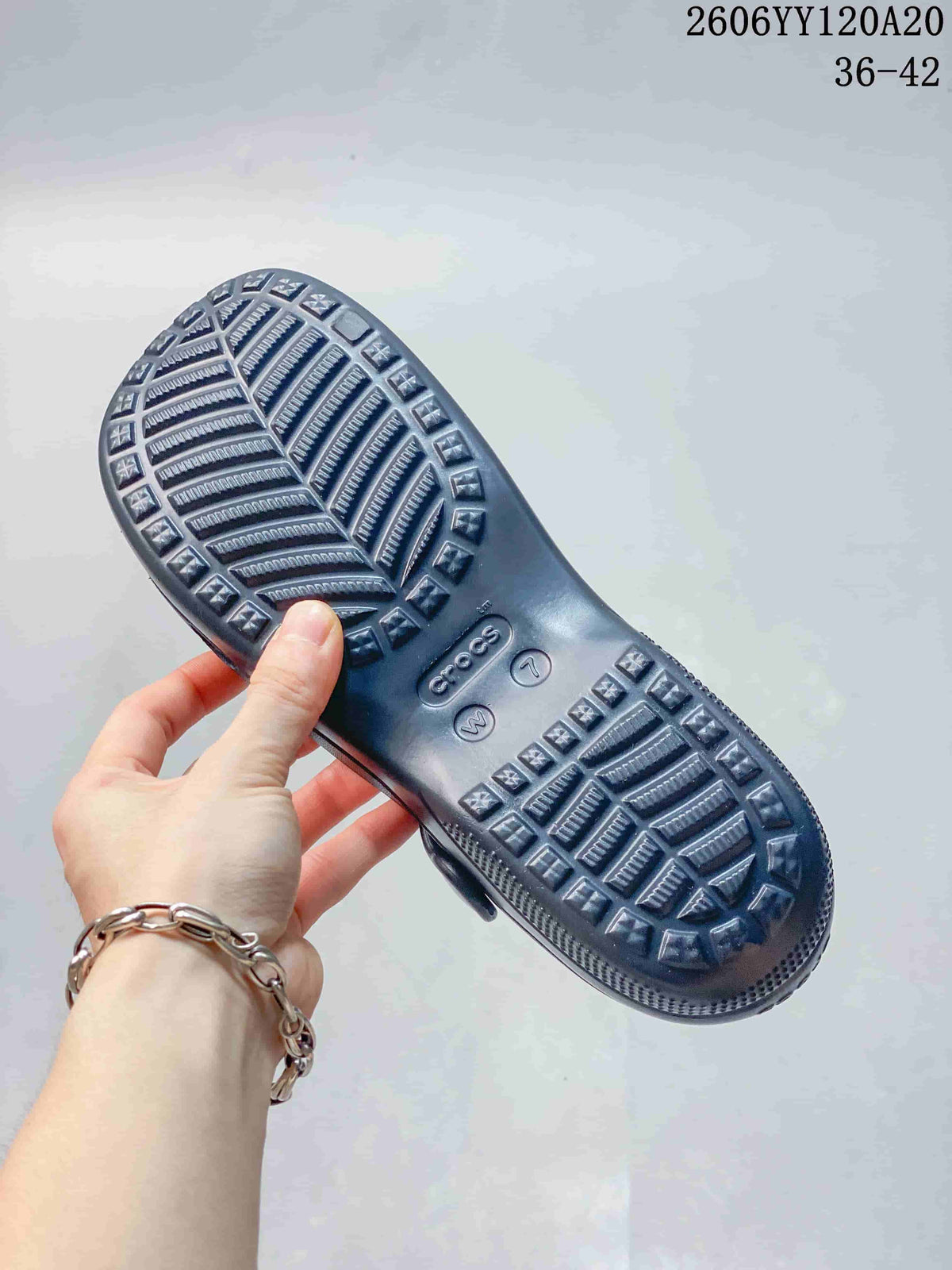 Close-up of the patterned outsole of a navy clog-style shoe; image text shows style code 2606YY120A20 and sizes 36–42.