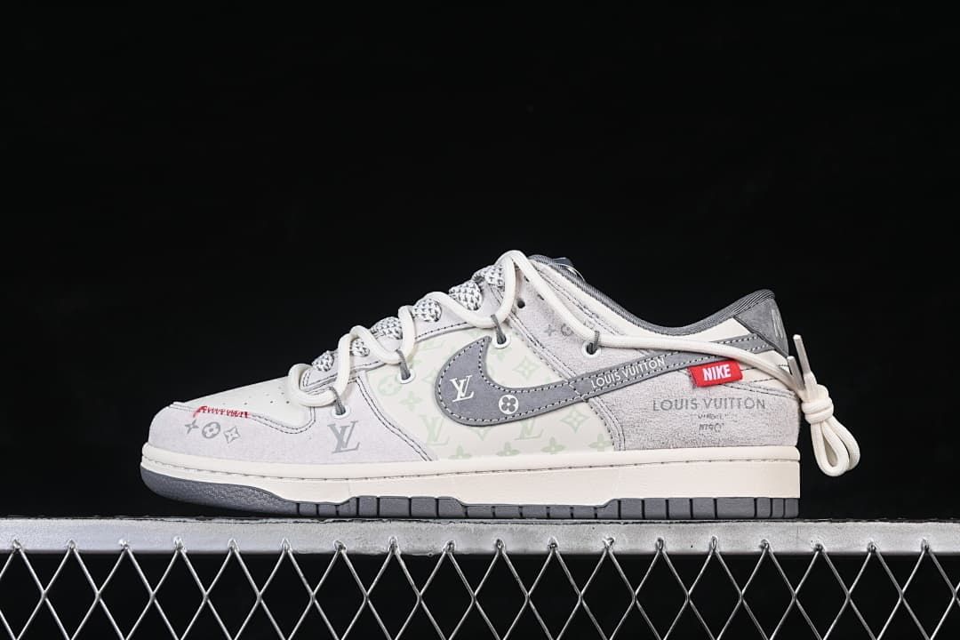 Side view of light gray and off-white low-top sneakers with patterned panels, a gray swoosh, red tag accent, and heel lace detail.