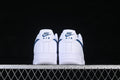 Rear view of white Nike Air Force 1 ’07 sneakers with navy heel details