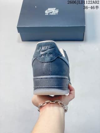 Rear view showing the heel branding and padded collar of the black Nike Air Force 1 sneaker.