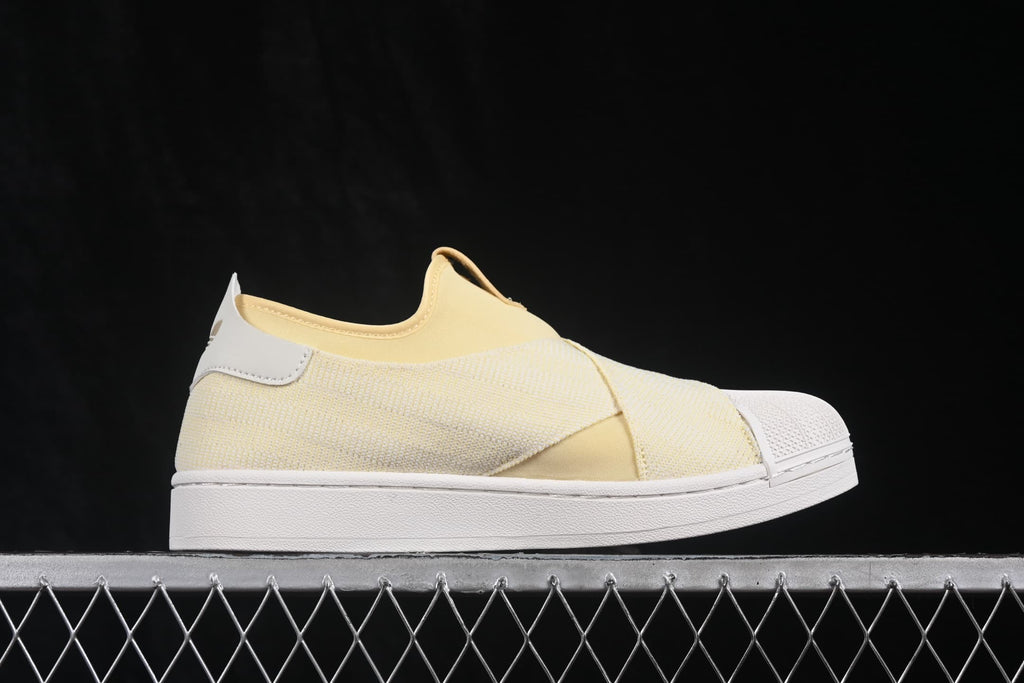 Side profile of the cream slip-on sneaker with white shell toe and sole.