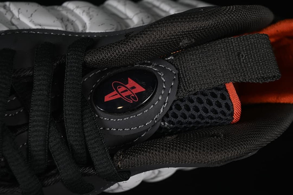 Top detail of black laces, mesh tongue, and logo accent.