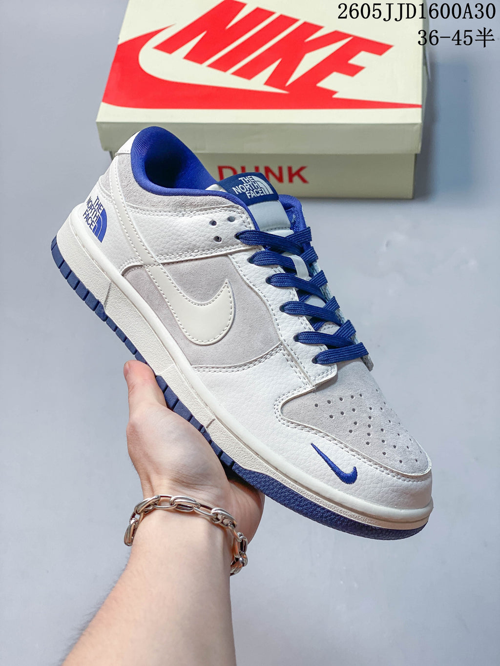 White low-top sneaker with blue laces and blue accents